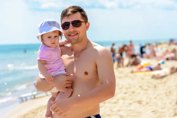 Junger Vater mit Sonnenbrille am Strand mit kleiner Tochter — Stockfoto