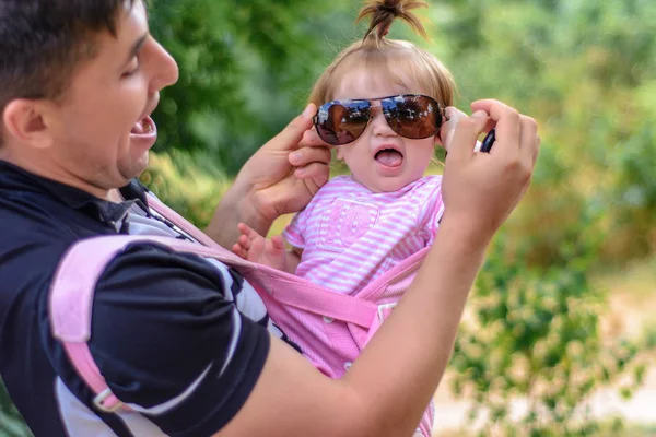 Menina incrível está brincando com óculos de sol com seu pai — Fotografia de Stock