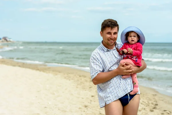 Un jeune père tient ses filles la main sur la plage — Photo