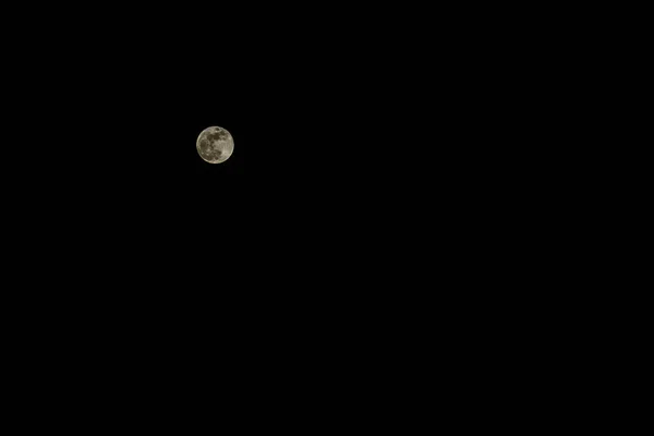 黑色背景下的低键满月的真实快照 — 图库照片