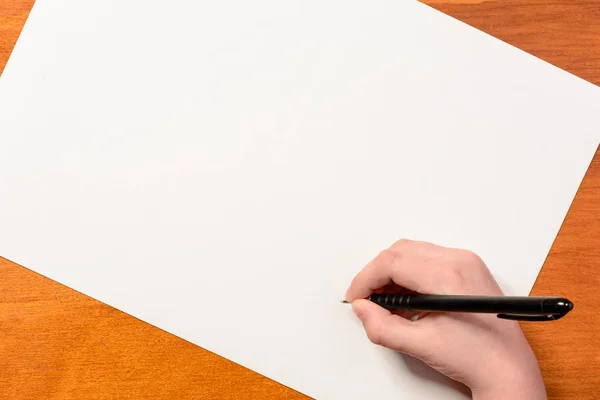 Mão de um menino com uma caneta preta em um fundo branco — Fotografia de Stock
