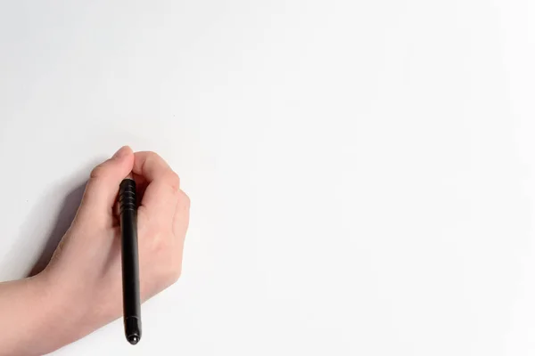 Mano de un niño pequeño con una pluma negra sobre un fondo blanco —  Fotos de Stock