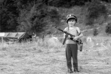 Küçük bir çocuk onun şapkalı bir kupa silahtan Mp-40 İkinci Dünya Savaşı tutar