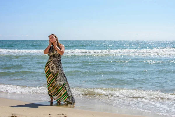 Belle fille debout sur la plage de la mer Noire en lunettes de soleil et robes — Photo