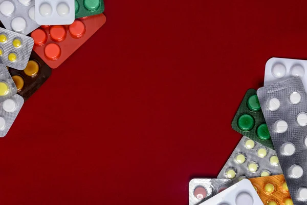 Opakowania tabletek znajdują się na czerwonym tle z miejscem — Zdjęcie stockowe