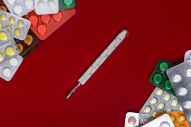 Haplarla çevresinde ve kırmızı bir arka plan üzerinde termometre