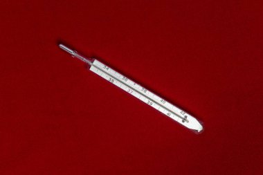 Kırmızı kumaş üzerine izole Mercury termometre