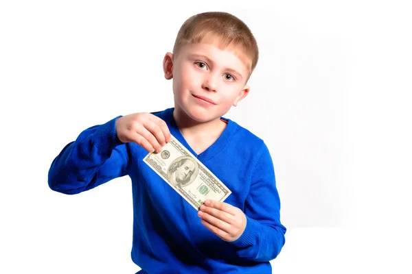 A little boy in a blue sweater smiles and holds a hundred dollars — Stock Photo, Image