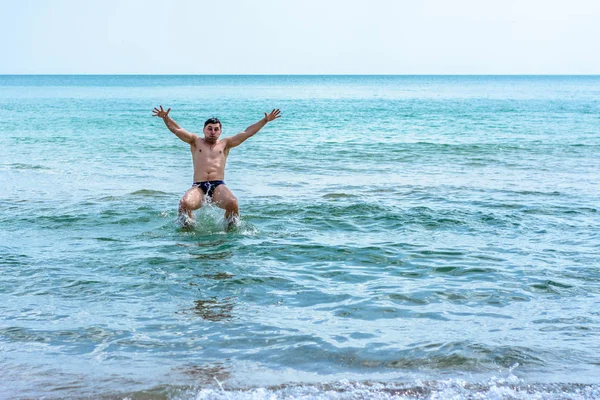 Un sportif sautant par-dessus les vagues de la mer dans la mer Noire — Photo