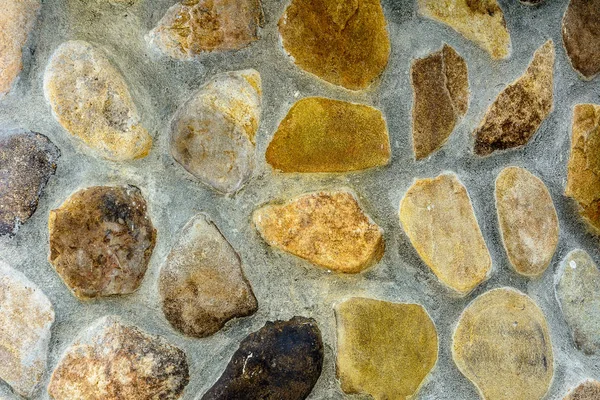 Amazing background of textured river stones laid out on a cement mortar — Stock Photo, Image