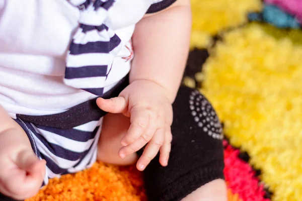 Çizgili bir gömlek ve şapkalar odasında mindere oturmuş güzel bir bebek