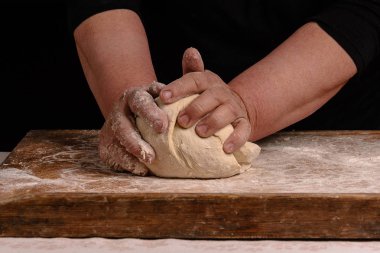 Yaşlı bir kadının büyükanne ekmek yemek pişirmek için bir hamur yoğurma