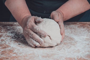 Yaşlı bir kadının büyükanne ekmek yemek pişirmek için bir hamur yoğurma