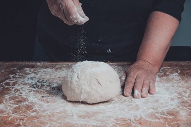 Eski bir anneanne elinde un hamur ile serpin