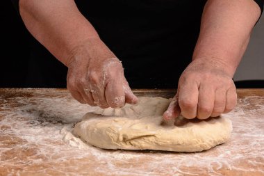 Yaşlı bir kadının büyükanne ekmek yemek pişirmek için bir hamur yoğurma