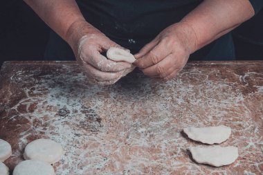 Karanlık bir arka plan üzerinde eski bir büyükanne kalıp vareniks eller