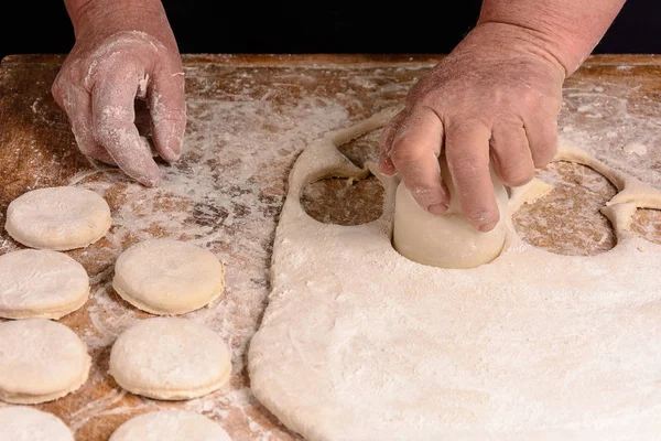 Abuela aprieta un vaso de un círculo en una masa sobre la mesa —  Fotos de Stock