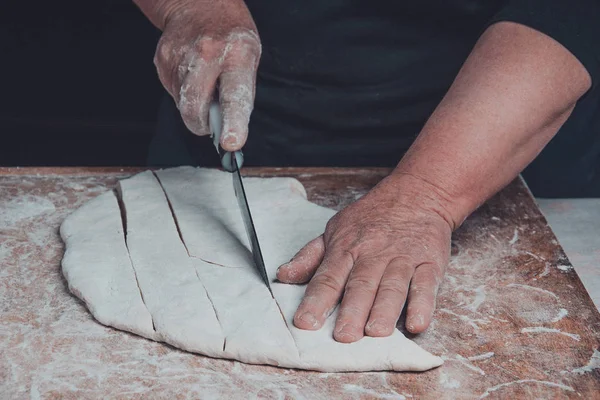 A szakács szeletelők nyers tésztát egy kést, egy keskeny vonal — Stock Fotó
