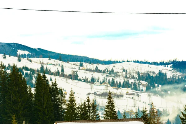 A aldeia montanhosa é visível na pitoresca paisagem de inverno . — Fotografia de Stock