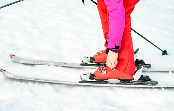 Esquís, botas y palos en rojo en la pierna de la mujer de cerca . — Foto de Stock