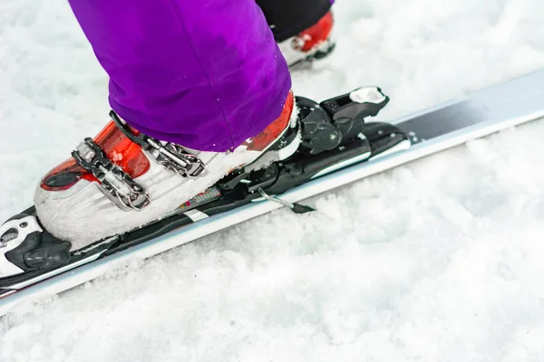 Der Athlet zeigt einen Satz Skier und Stiefel am Bein. — Stockfoto
