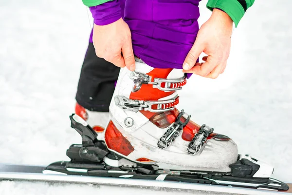 Der Athlet zeigt einen Satz Skier und Stiefel am Bein. — Stockfoto