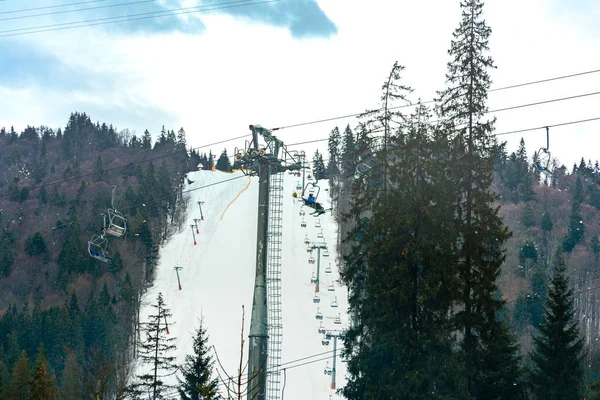 Skipiste mit Lift auf dem Hintergrund des immergrünen Karpatenwaldes, Bukovel Resort, Karpaten, Ukraine. — Stockfoto