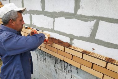 İşçi köyde ön tuğla duvar döşeme.