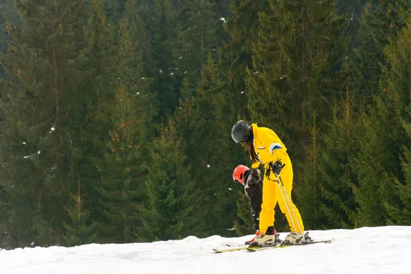 Mutter bringt ihrem Sohn das Skifahren in den schneebedeckten Karpaten der Ukraine bei. — Stockfoto