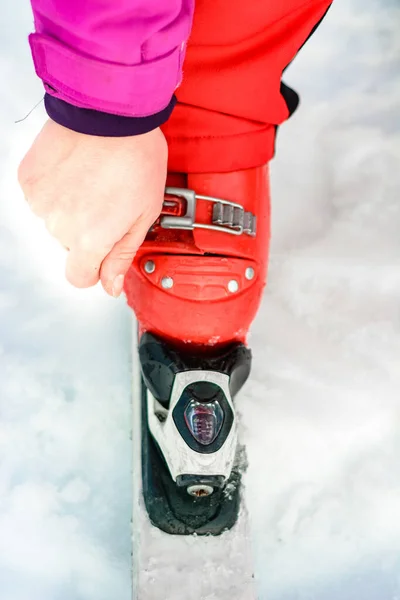 Narciarz w czerwonym stroju narciarskim i czerwonych butach narciarskich i białych nartach, zbliżenie. — Zdjęcie stockowe