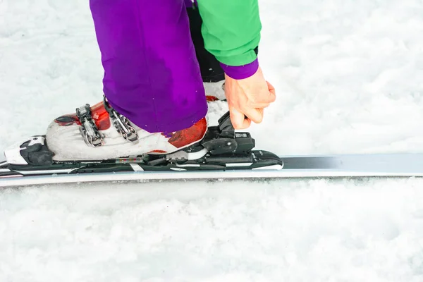 Der Athlet zeigt einen Satz Skier und Stiefel am Bein. — Stockfoto