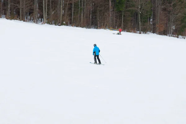 Esquiadores descienden en las laderas de las laderas de los Cárpatos y las montañas, en el fondo son pintorescos paisajes y pistas de esquí . —  Fotos de Stock