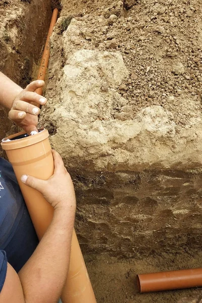 The employee connects the sewer pipes and connects them to the s