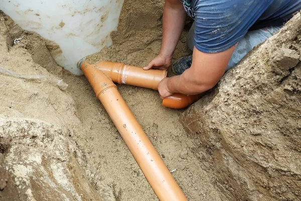 Fornitura di un tubo fognario ad una sump su una trincea nel villaggio . — Foto Stock