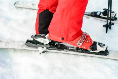 Yablunytsya, Ukrayna 2 Şubat 2019: Kırmızı pantolonlu kadın Yablunitsa köyünde Ukrayna turistleri kayak botlarını bağlıyor.