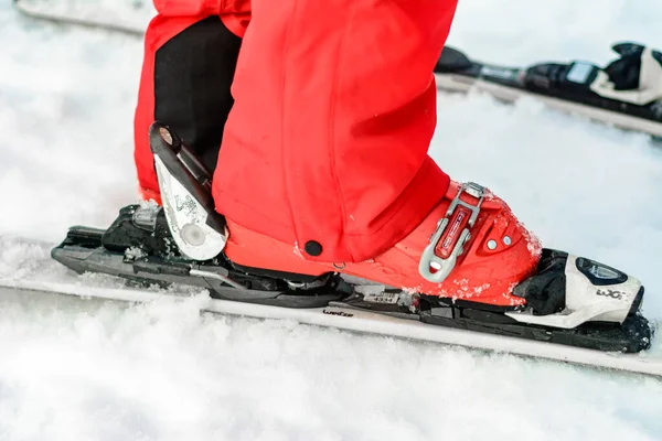 Jablunytsya, ukraine februar 2019: Frau in roter Hose schnallt Skischuhe an, ukrainische Touristen im Dorf jablunitsa. — Stockfoto