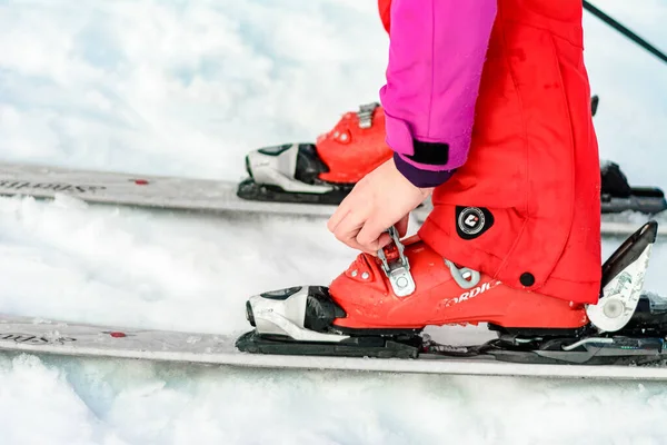 Jablunytsya, ukraine februar 2019: Frau in roter Hose schnallt Skischuhe an, ukrainische Touristen im Dorf jablunitsa. — Stockfoto