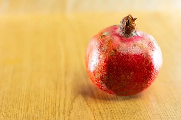 Red ripe pomegranate one and brown background. — Stock Photo, Image