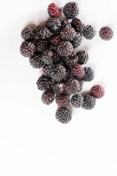 Frambuesas rojas y negras dulces fragantes sobre un fondo blanco . —  Fotos de Stock