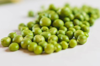 Taze taze bezelyelerle dağılmış beyaz bir zemin üzerinde, bir yazıt için bir yer vardır..