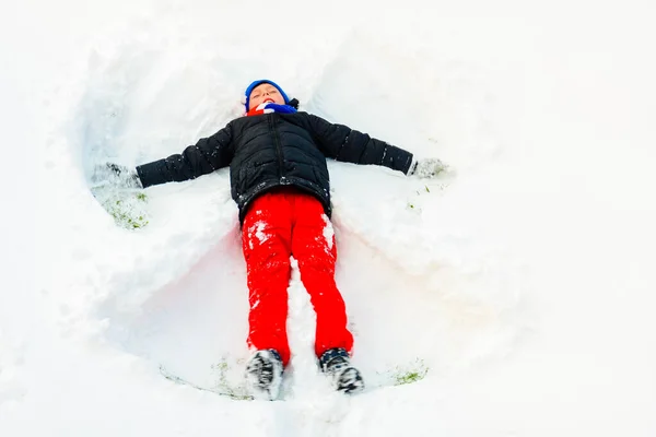 En ängel i snön gjord av en pojke. — Stockfoto