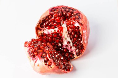 Beyaz zemin üzerinde olgun, sulu kırmızı bir nar..