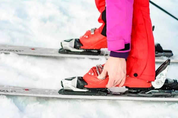 Jablunytsya, ukraine februar 2019: Frau in roter Hose schnallt Skischuhe an, ukrainische Touristen im Dorf jablunitsa. — Stockfoto