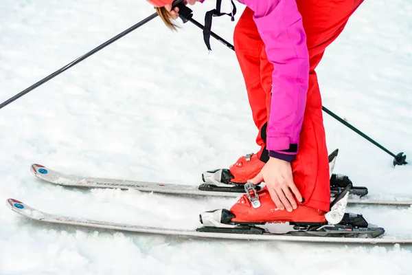 Yablunytsya, Ucrania 2 de febrero de 2019: mujer en pantalones rojos sujeta botas de esquí, turistas de Ucrania en el pueblo de Yablunitsa . — Foto de Stock