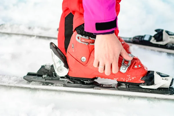 Yablunytsya, Ukraina Februari 2, 2019: kvinna i röda byxor fäster pjäxor, turister i Ukraina i byn Yablunitsa. — Stockfoto