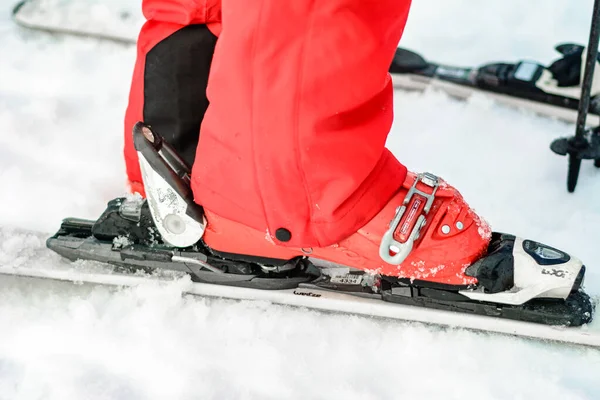Jablunytsya, ukraine februar 2019: Frau in roter Hose schnallt Skischuhe an, ukrainische Touristen im Dorf jablunitsa. — Stockfoto