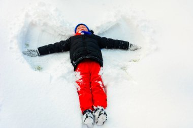 Kışın yakışıklı bir çocuk ayağında bir melek tasvir eder..