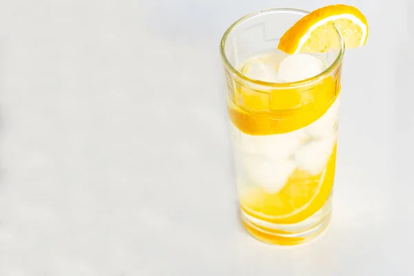 Склянка води з льодом і скибочками лимона на білому тлі . — стокове фото
