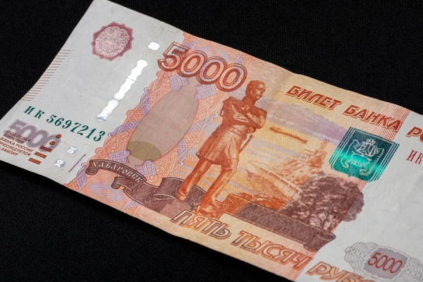 Un billete ruso en la cantidad de 5000 rublos se encuentra sobre un fondo negro . —  Fotos de Stock