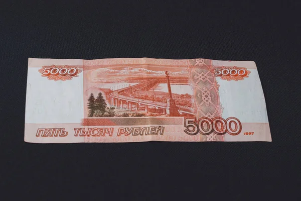 5000ルーブルの額のロシアの法案の1つは、黒い背景の後ろにあります。. — ストック写真